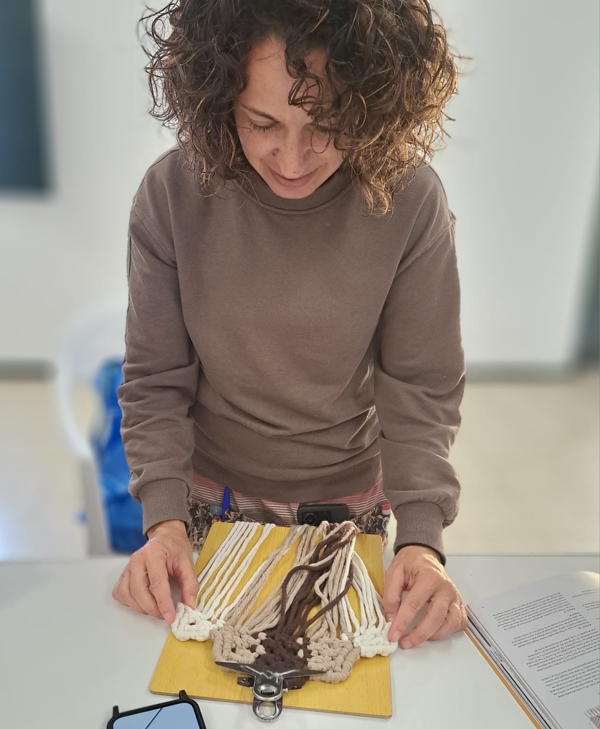 Profesora revisando trabajo de alumna de macramé